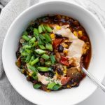 White bowl of 30 minute vegan Mexican chili with green onions