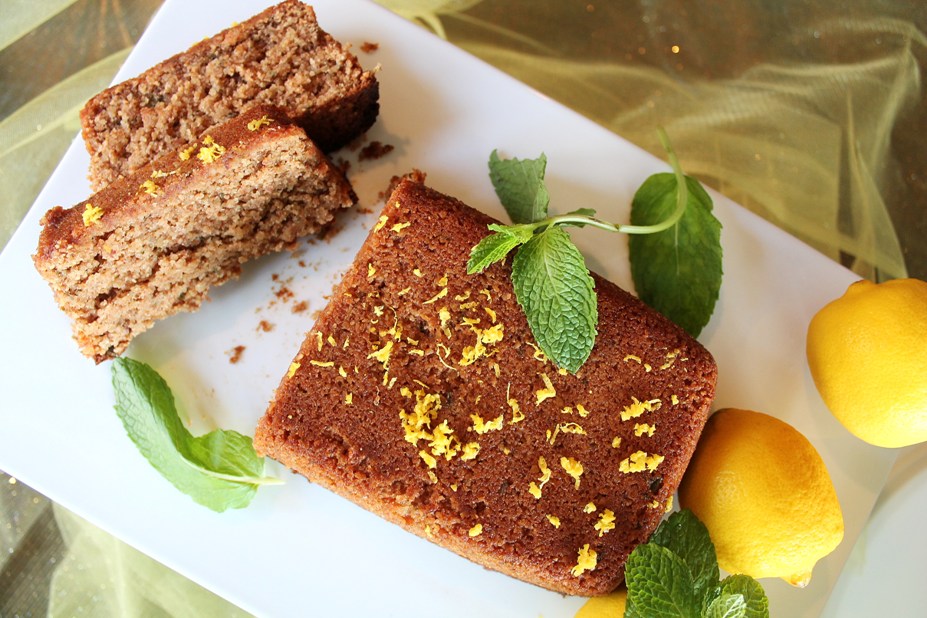 top of loaf with 2 slices and mint leaves around and fresh lemons