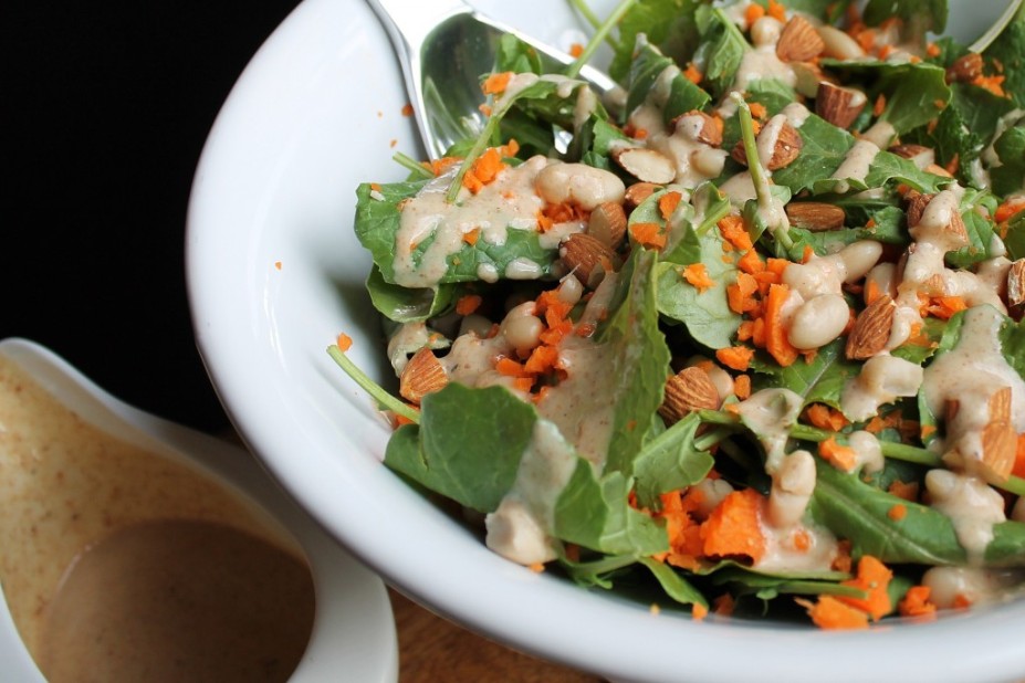 Oil-free almond butter dressing in a bowl next to salad