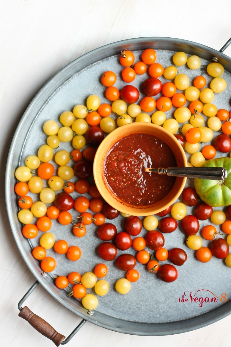 Bowl of homemade salsa on platter of tomatoes