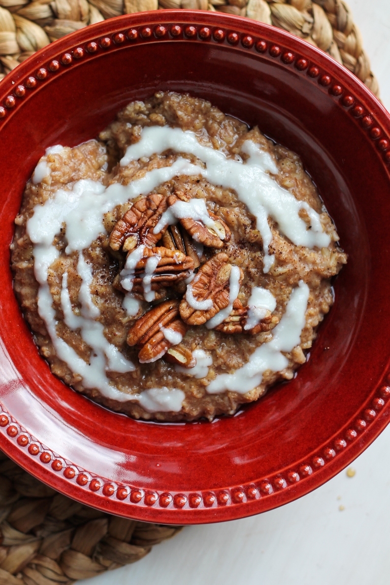 overhead shot of red bowl of cinnamon roll oatmeal with icing