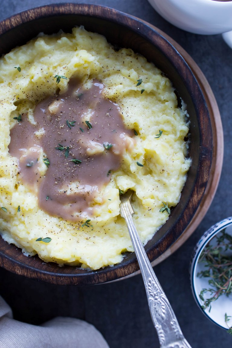 Bowl with fork and wine gravy over vegan mashed potatoes