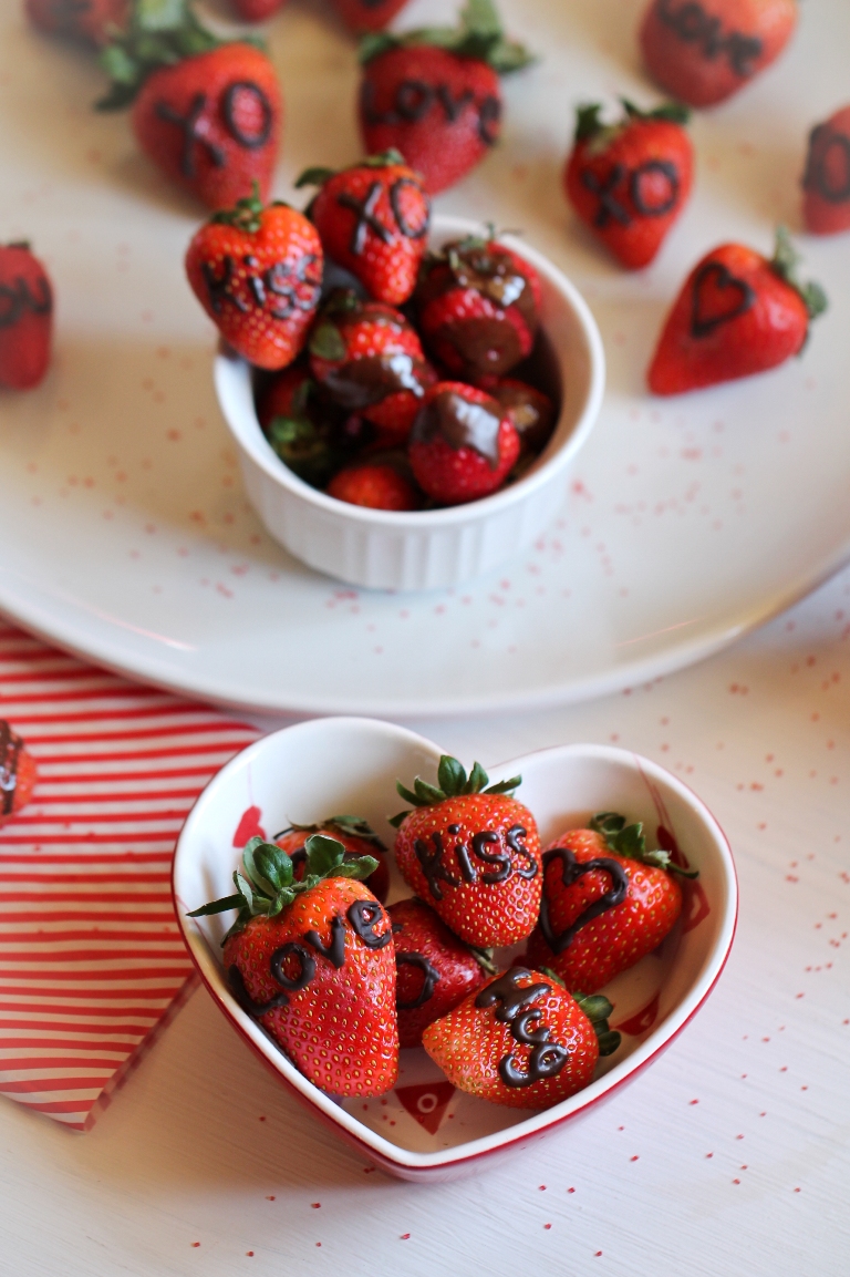 Bowl of strawberries with chocolate writing on them
