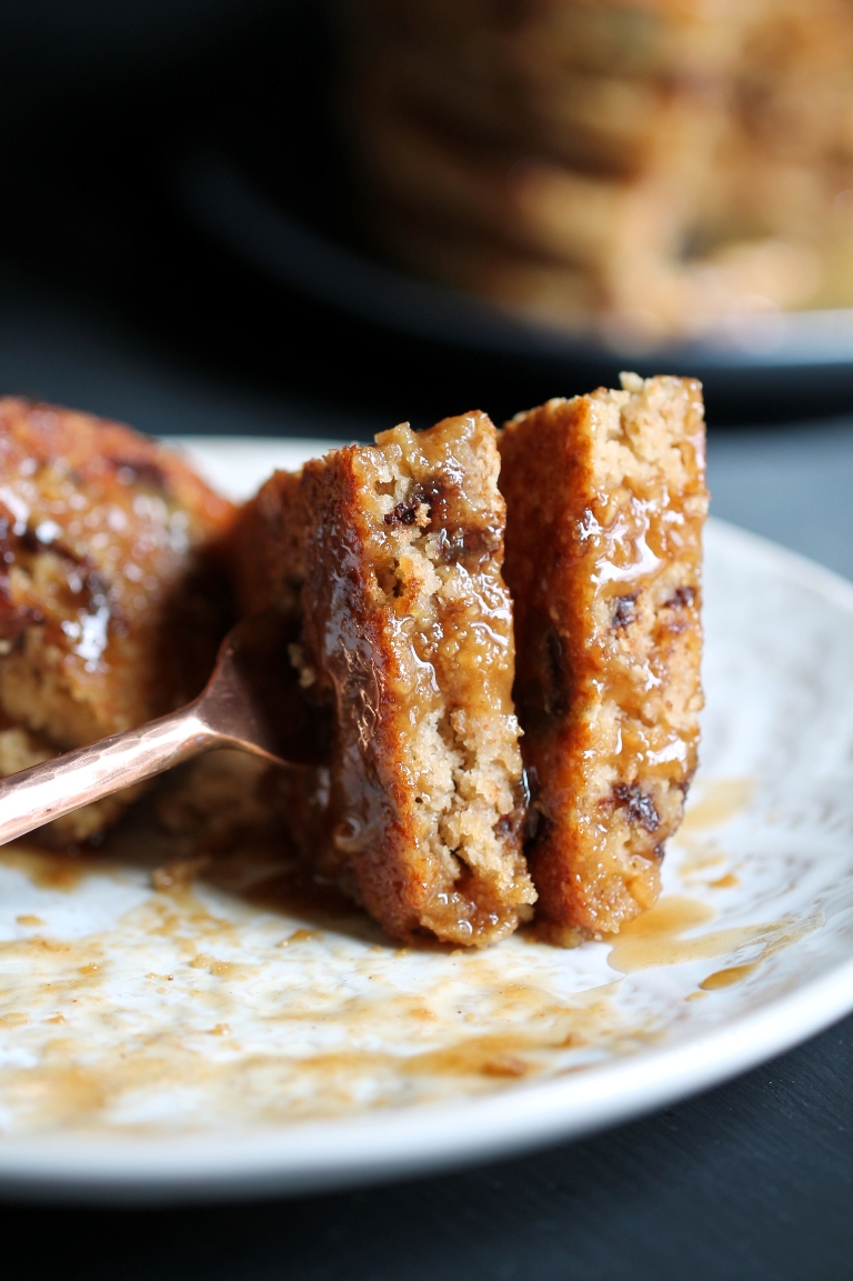 Fork holding 2 bites of pancakes with syrup