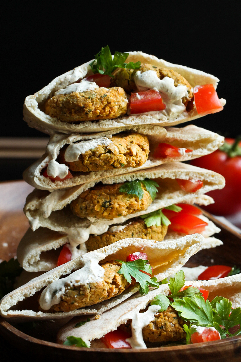 stacked pitas filled with falafel and tomatoes and lemon cream sauce