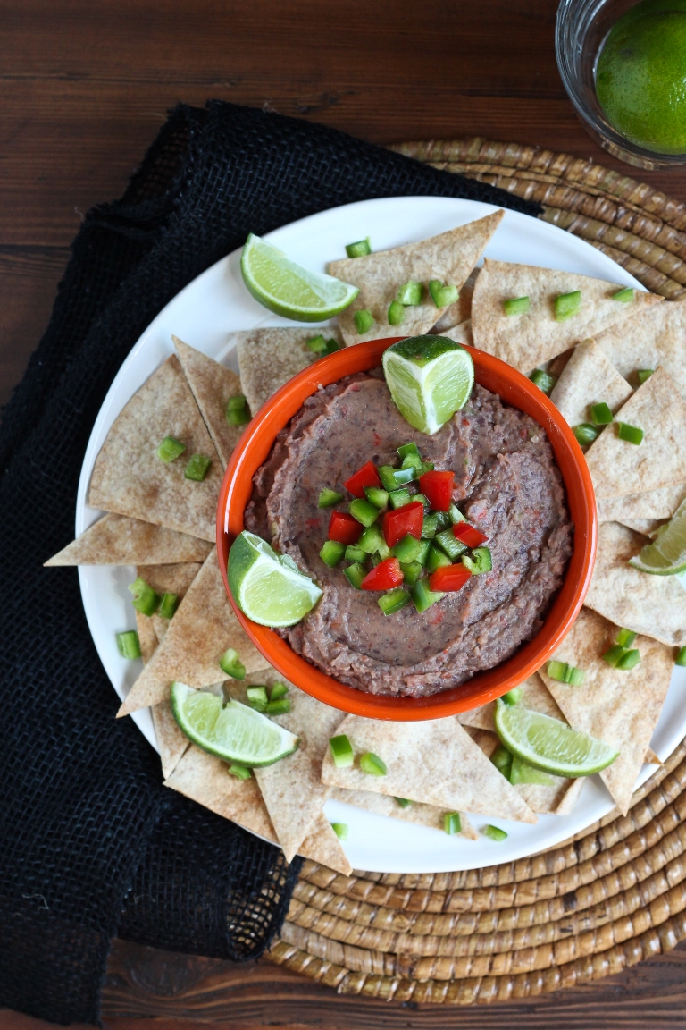 Smoky jalapeno black bean dip in bowl on plate with chips
