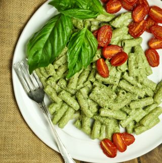 white plate of basil pesto with roasted cherry tomatoes