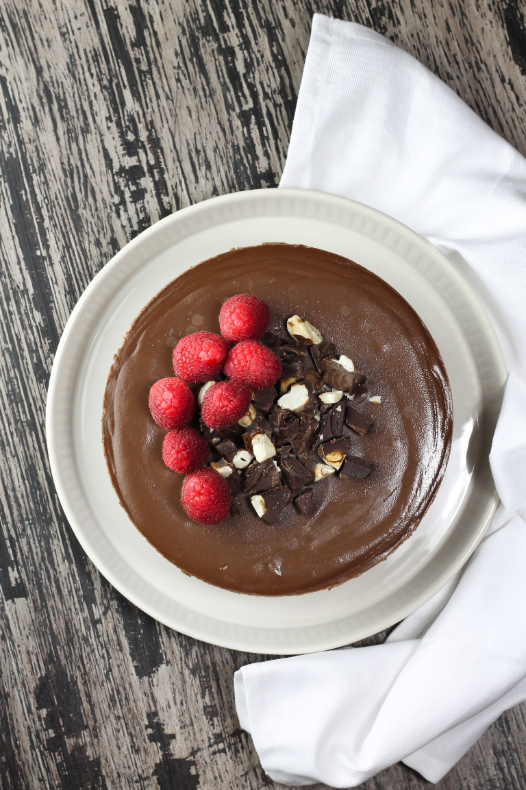 Overhead view of vegan chocolate cheesecake with raspberries