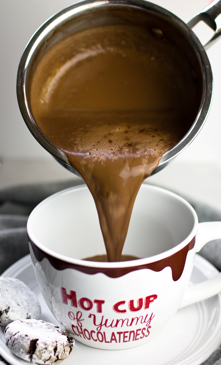 Pouring vegan hot chocolate from pot into a mug