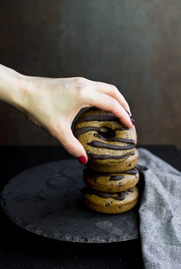 Lady hand grabbing a donut from a stack