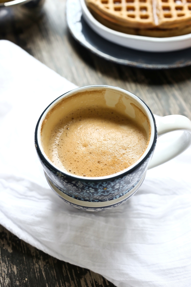 Cup of vegan cappuccino on white napkin