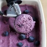 ice cream scoop in dish of blueberry ice cream