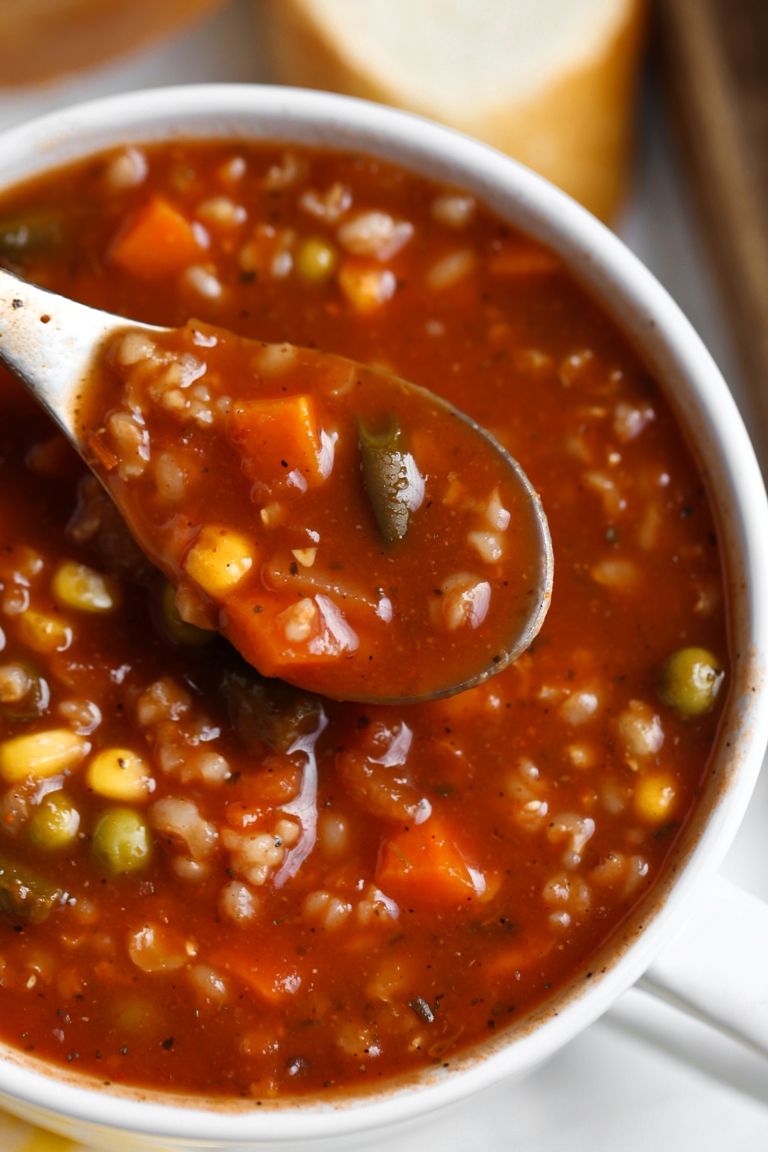 Closeup view of spoon in a bowl of tomato vegetable soup