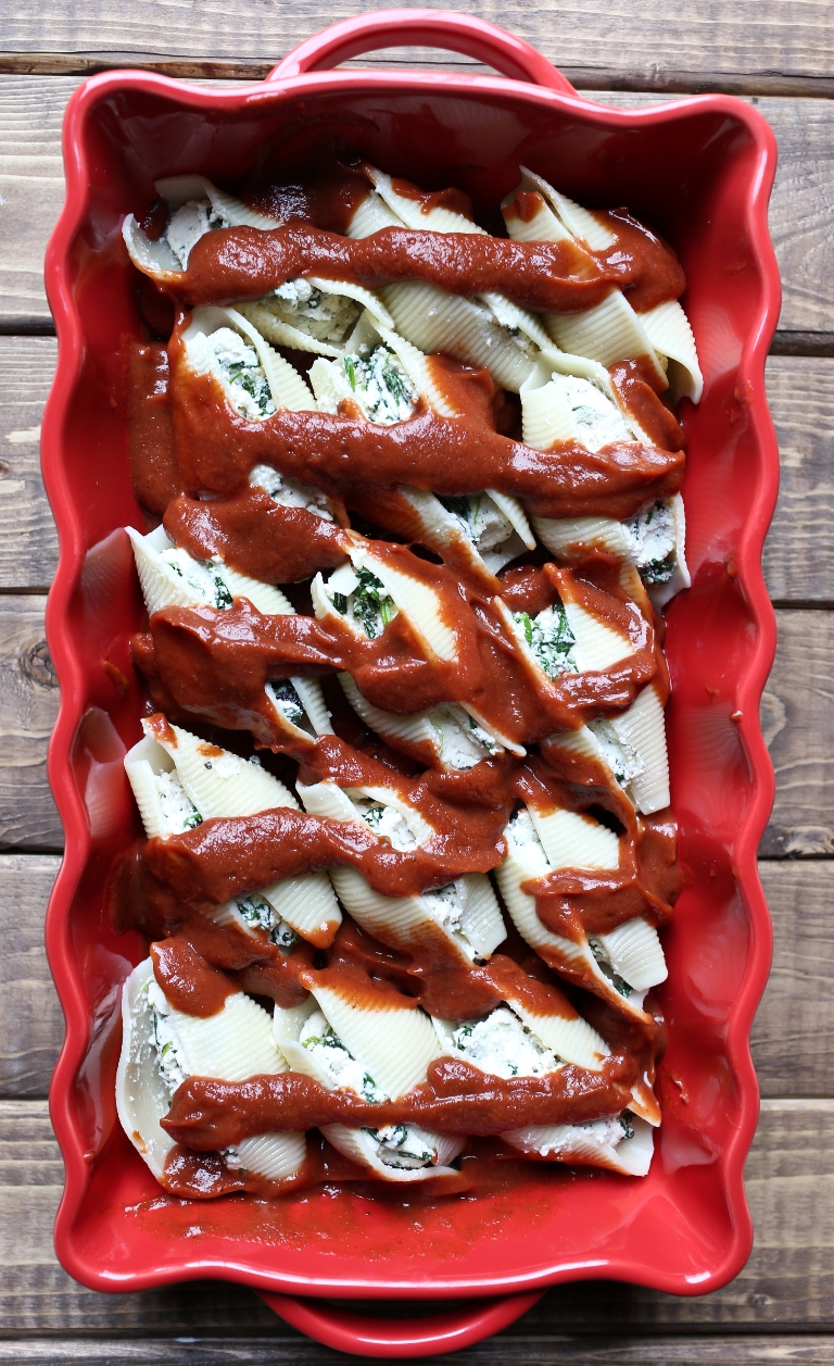 Pre-baked red casserole dish with jumbo shells and ricotta and marinara