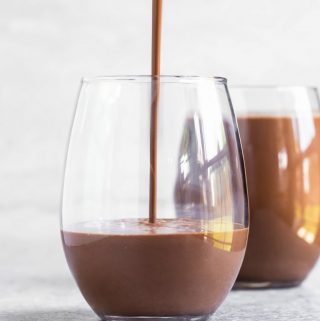 Pouring homemade vegan chocolate milk into glass