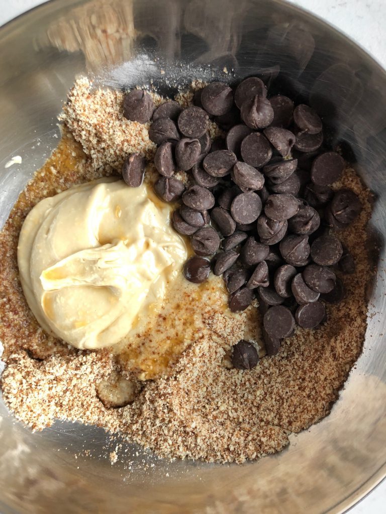 Almond flour, cashew butter, syrup and chocolate chips in bowl