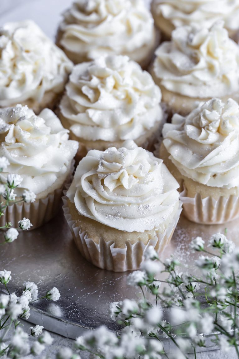 Silver platter of vegan white wedding cupcakes with white frosting.
