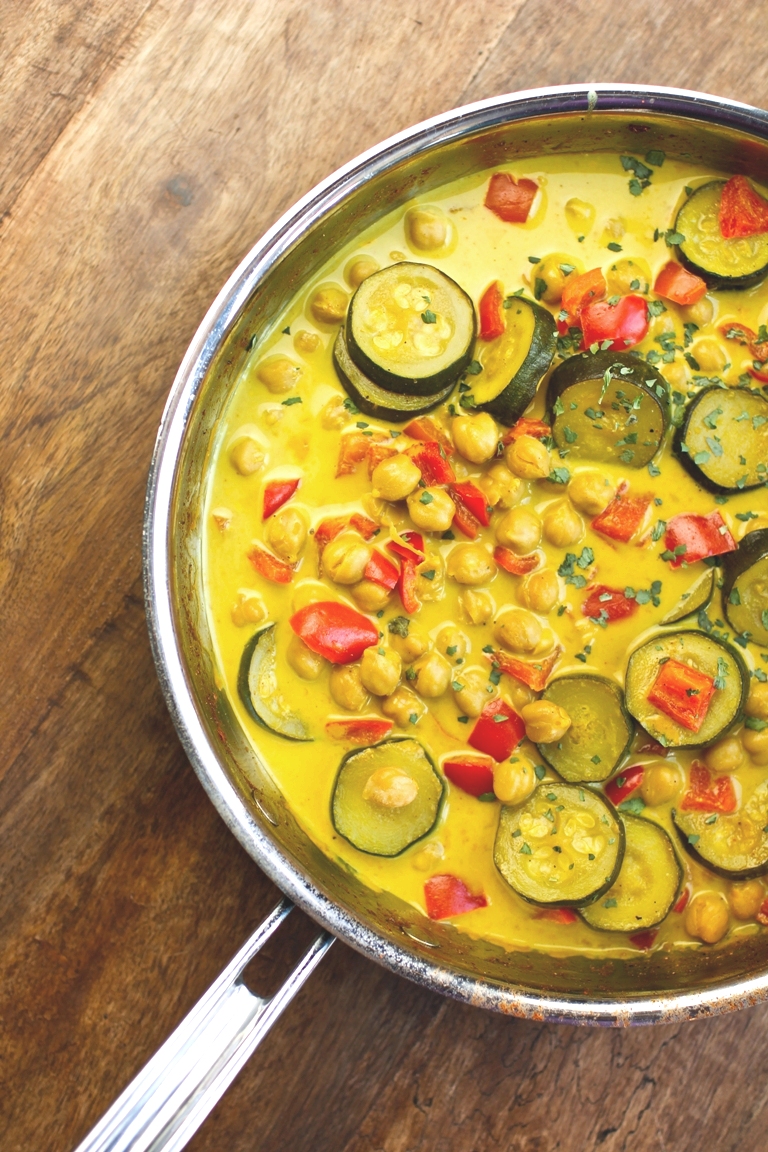 bright colorful curry with bell peppers and zucchini in pan