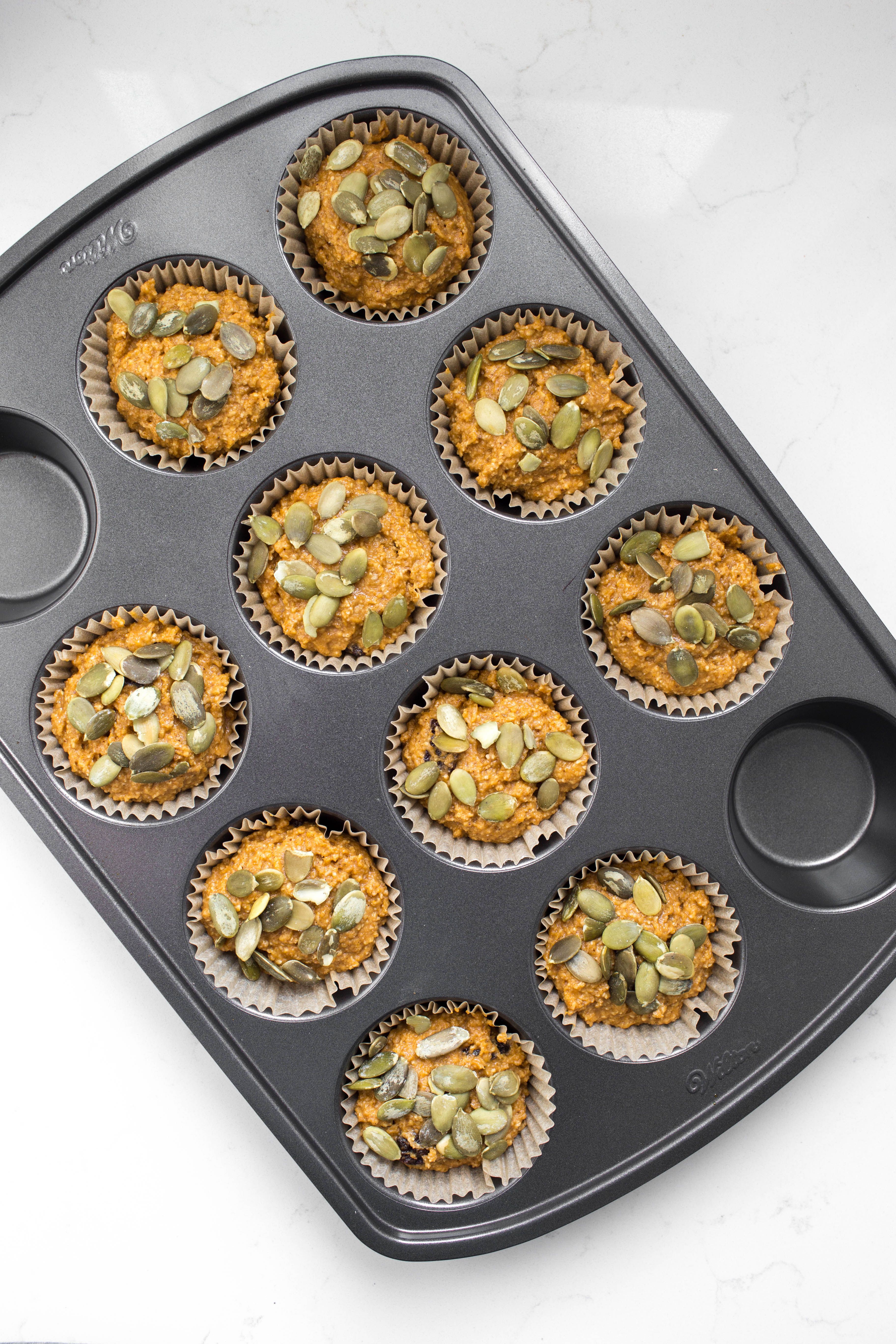 Muffin pan with pre-baked vegan pumpkin batter