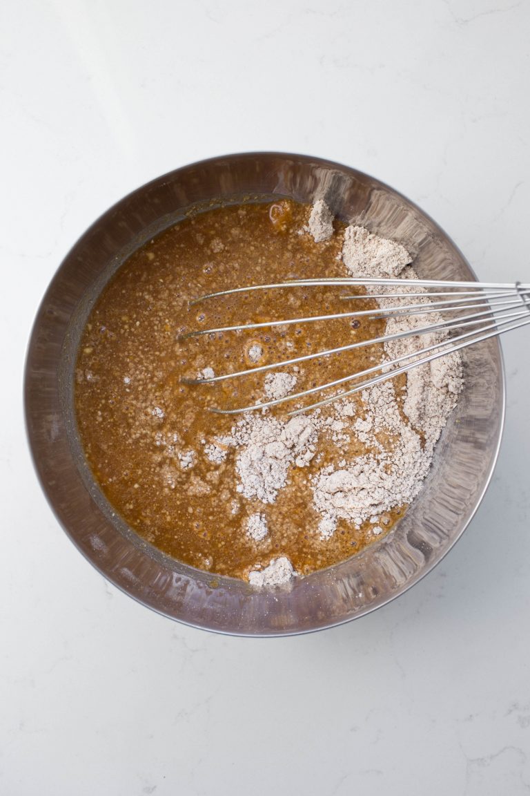 Silver bowl and whisk with pumpkin and maple syrup added