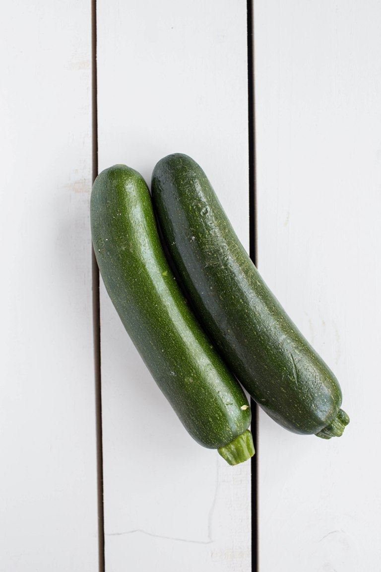 2 zucchini on white table