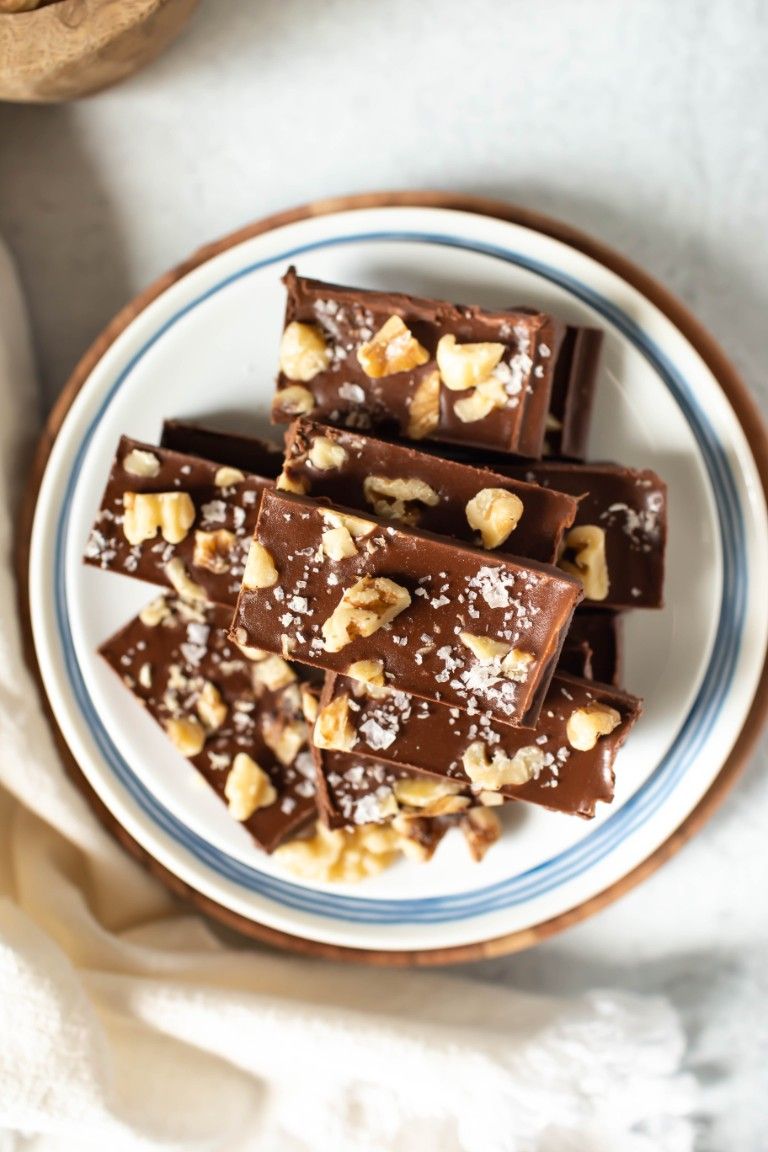 white plate of stack of vegan fudge with walnuts
