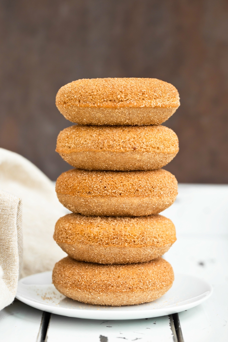 Stack of vegan cinnamon sugar donuts on white plate