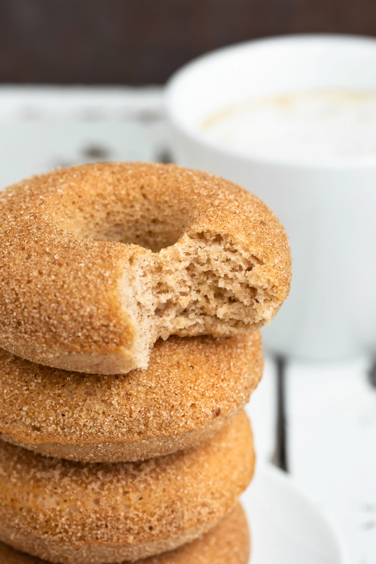 Stack of vegan cinnamon sugar donuts with bite missing