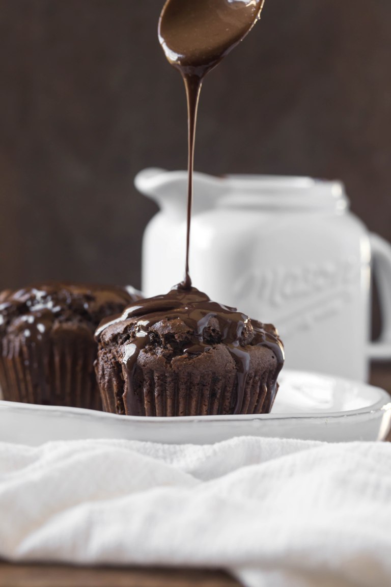 Vegan chocolate sauce drizzling above muffin