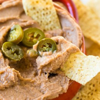 Vegan refried bean dip in bowl with chips