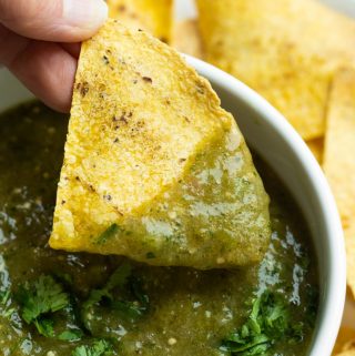 Hand dipping chip in roasted tomatillo salsa verde