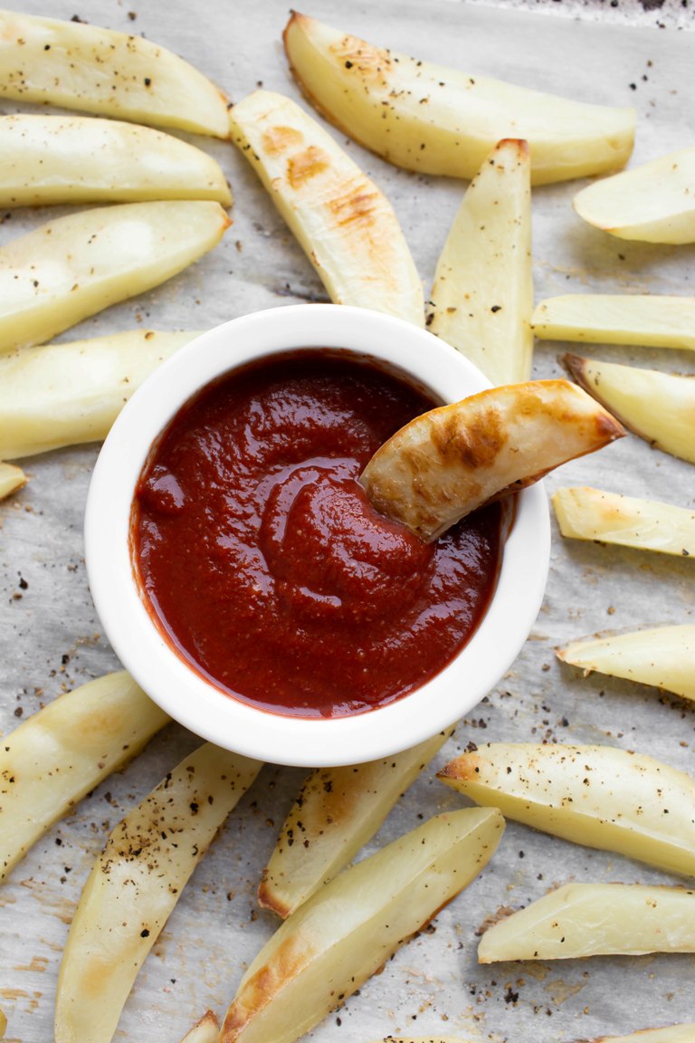 Dipping fry into bowl of homemade ketchup