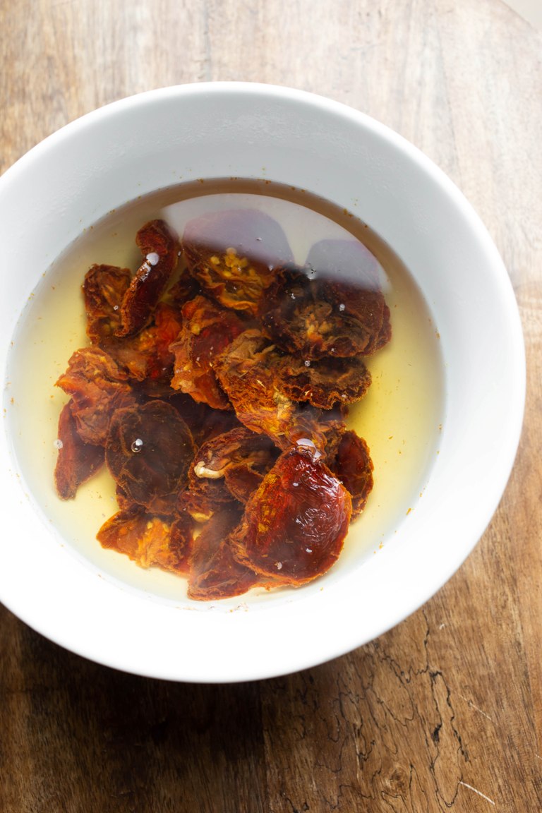 sun-dried tomatoes soaking in bowl of boiling water