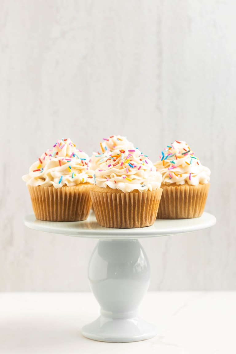 cake stand with vanilla cupcakes on top