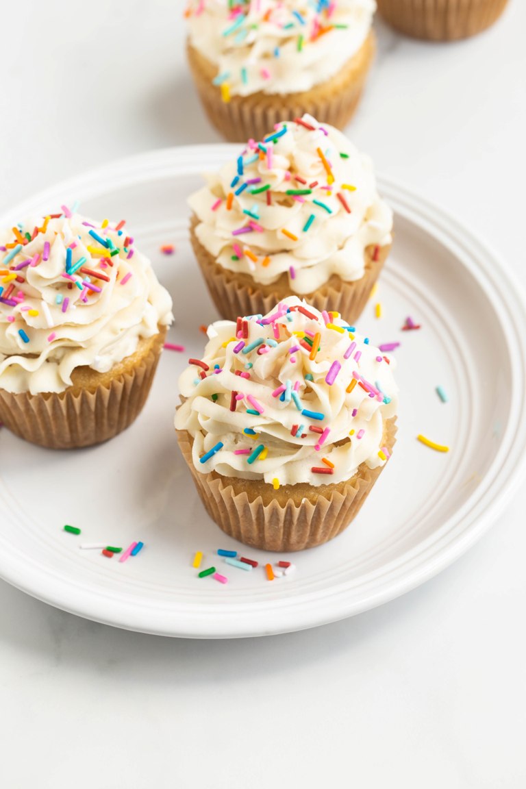 3 cupcakes with buttercream on a white plate