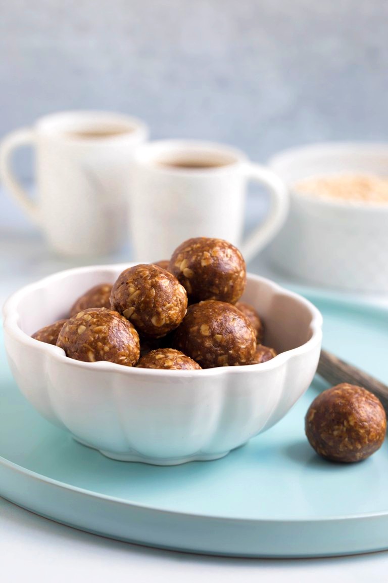 white bowl of chai balls with 2 cups of coffee