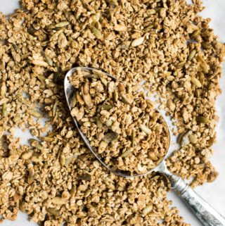 baked spiced buckwheat granola on pan with spoon in middle