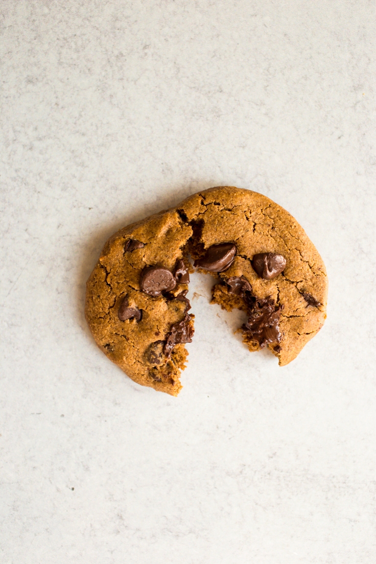 one vegan pumpkin cookie with melted chocolate chips