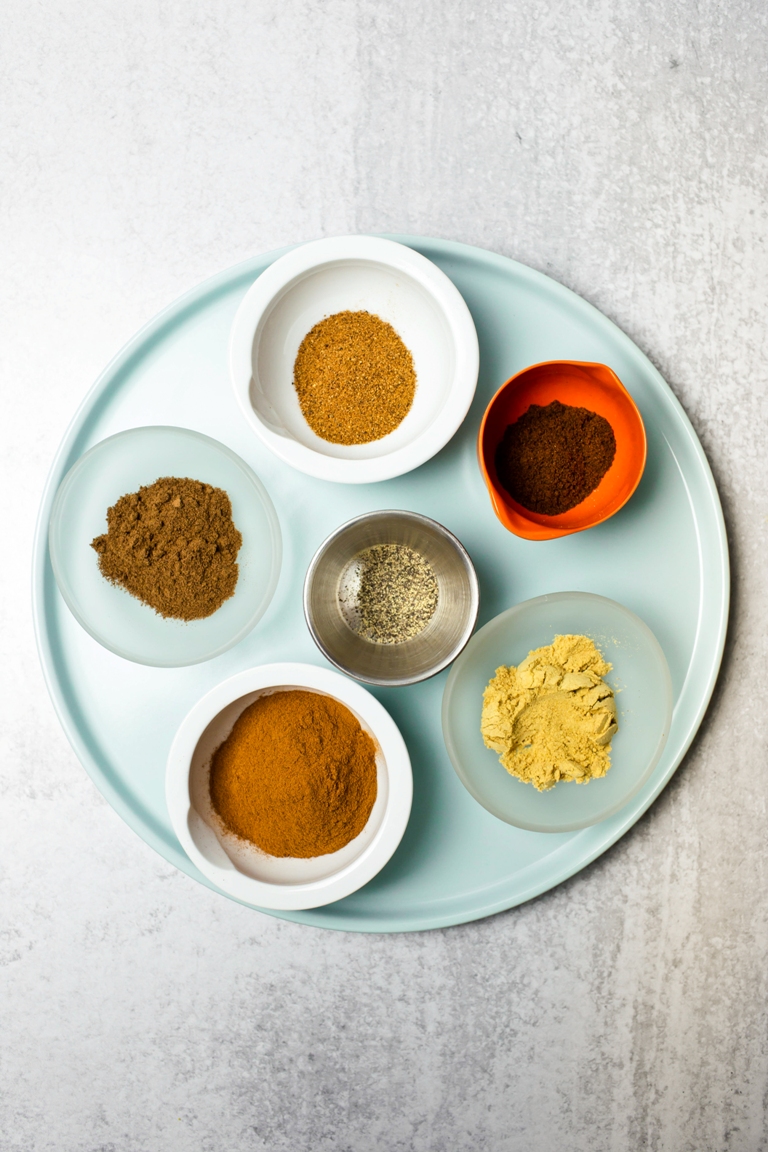 pumpkin pie spices in bowls on blue plate