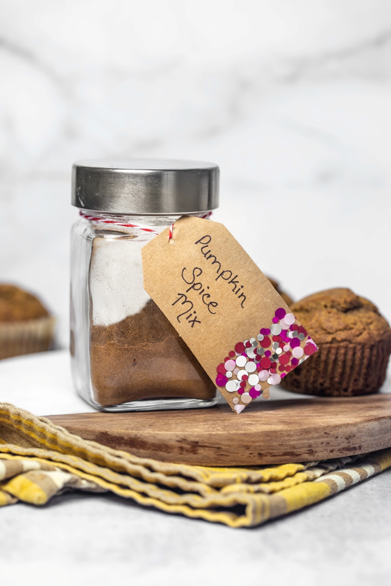 jar of homemade pumpkin pie spice next to pumpkin muffin