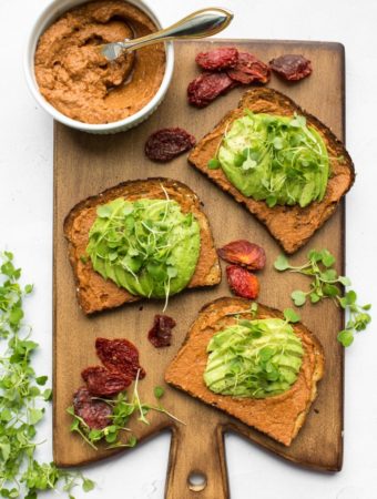 3 slices of avocado toast with bowl of sundried tomato spread