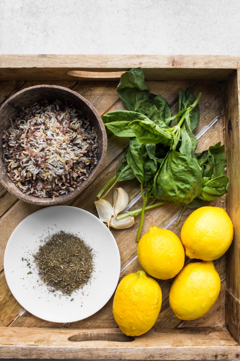 fresh lemons basil leaves wild rice italian seasoning in wood tray