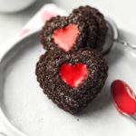 closeup of 2 heart chocolate cupcakes with red icing filling