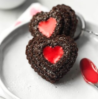 closeup of 2 heart chocolate cupcakes with red icing filling