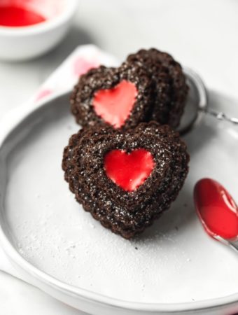 closeup of 2 heart chocolate cupcakes with red icing filling