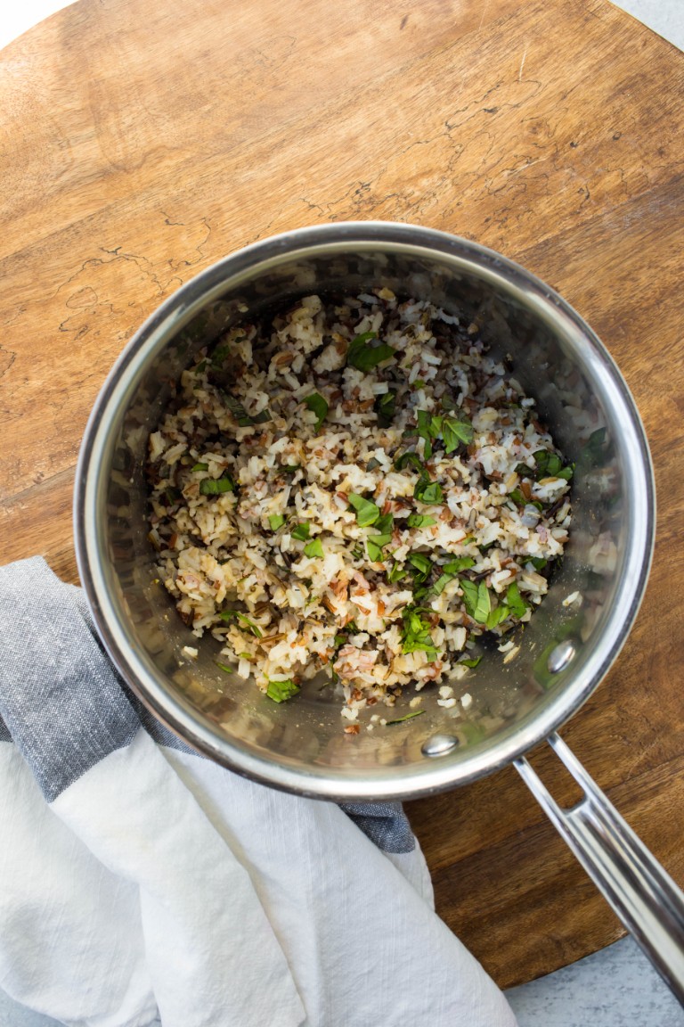 pot of cooked rice on wood board with white towel