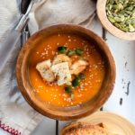 wood bowl with soup and croutons and fresh jalapeno