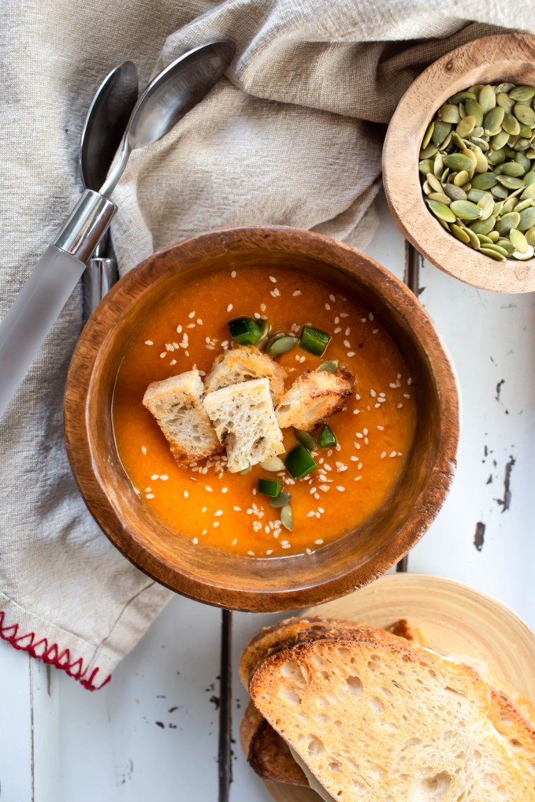wood bowl with soup and croutons and fresh jalapeno