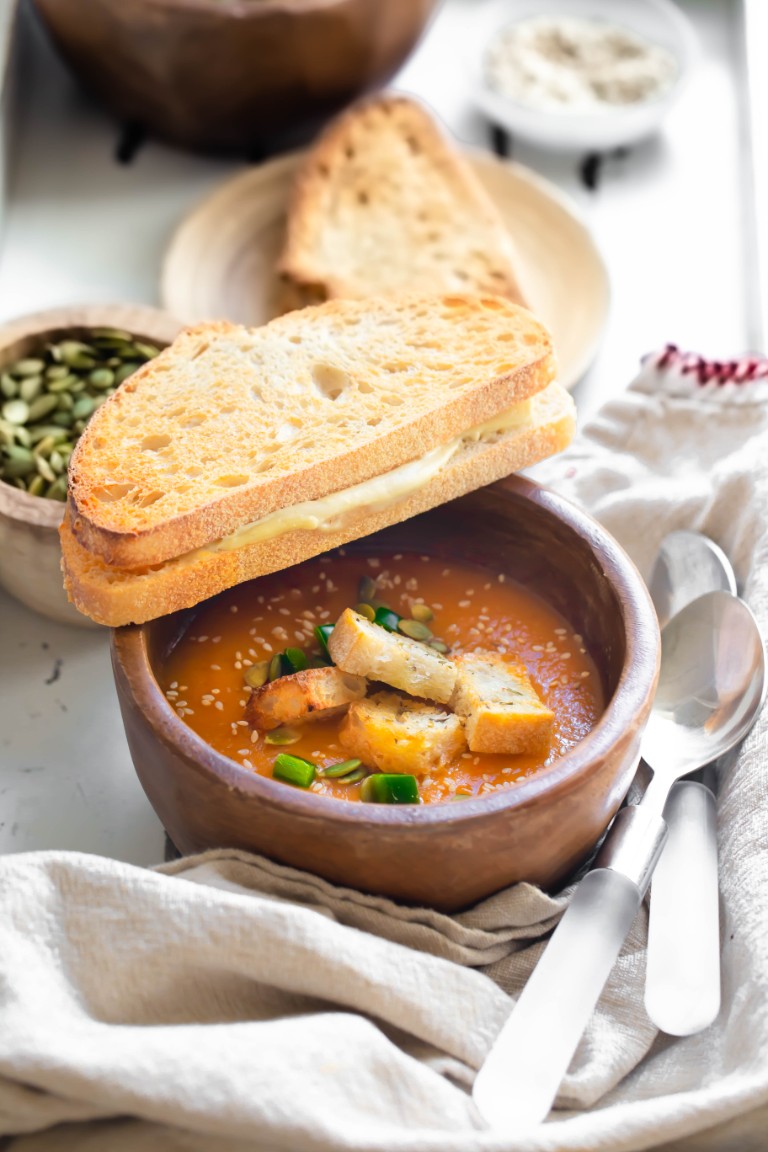 wood bowl of zucchini soup with grilled cheese
