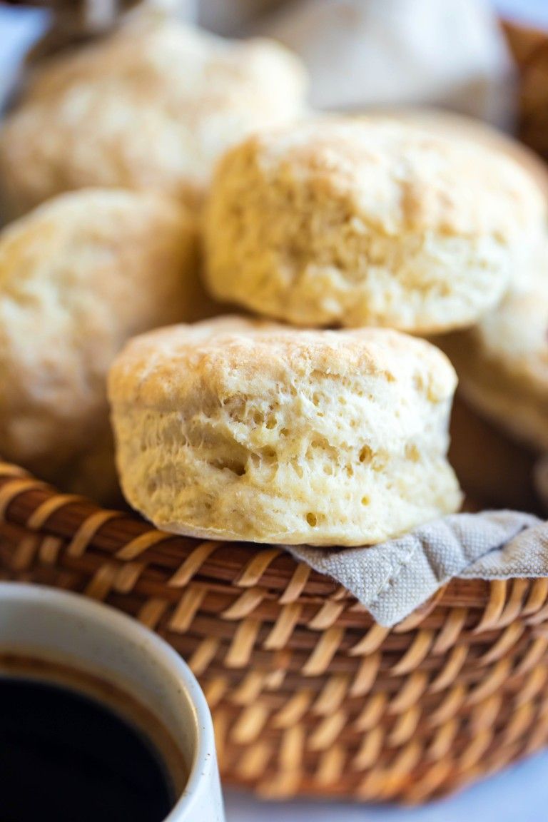 several biscuits in wicker basket with cup of coffee